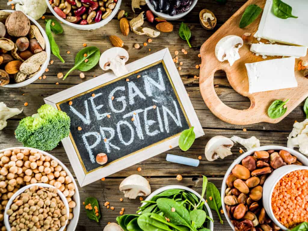 Vegan protein sources pictured on a wooden background with a blackboard